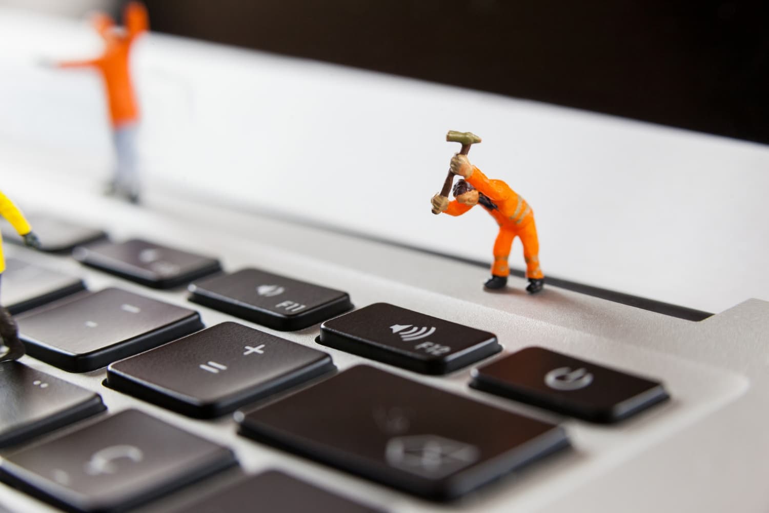 web site maintenance with little figures on laptop